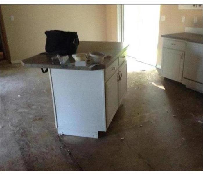 a clean kitchen with missing flooring