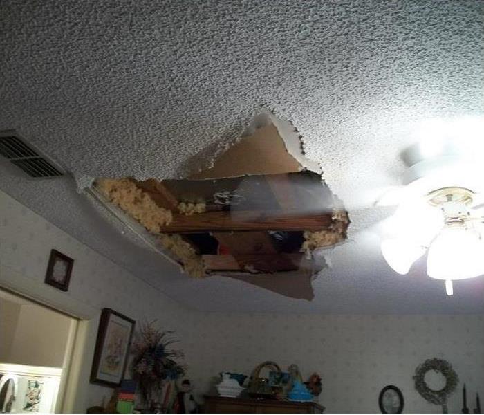 a ceiling with a portion missing and exposed drywall