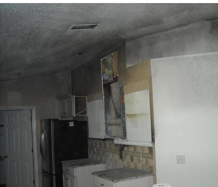 a kitchen with grey smoke on white walls