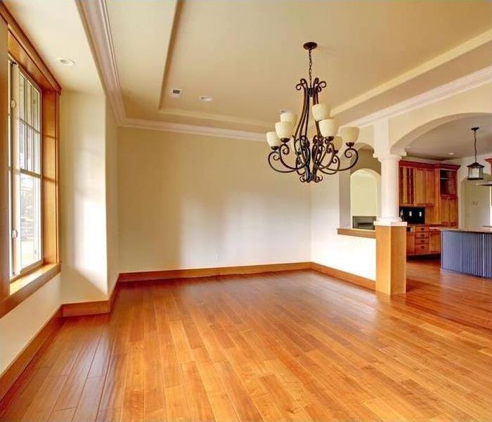 a clean dining room with hardwood floors and beige walls