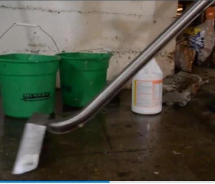 flooded parking garage with green buckets on the floor