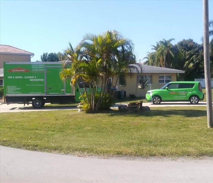 green SERVPRO vehicles outside a residence